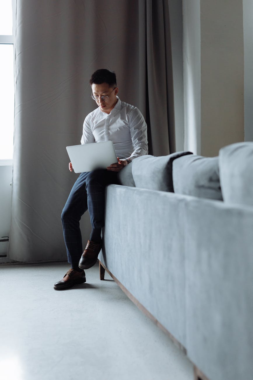 A thoughtful professional working on a laptop in a contemporary office space, emphasizing concentration and productivity.