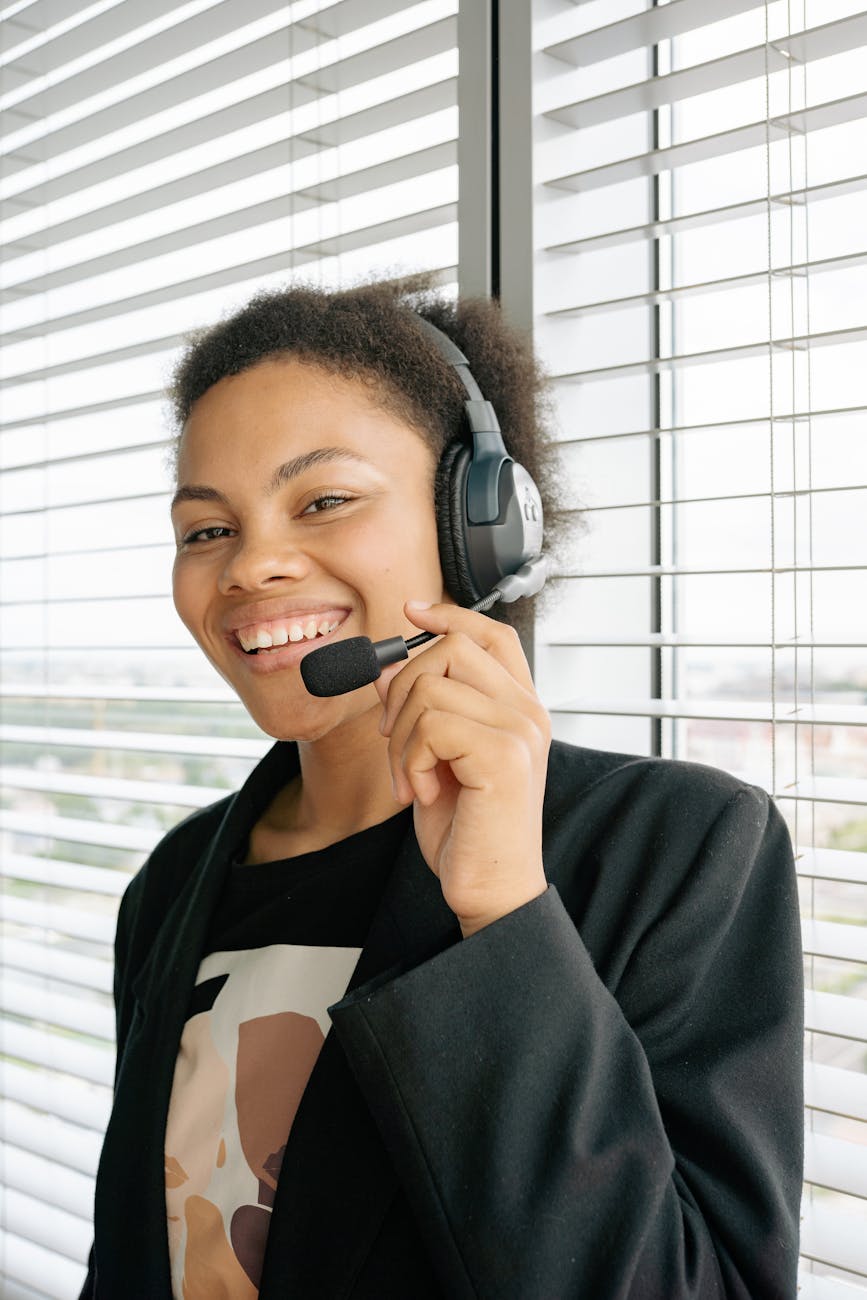 Friendly customer support agent wearing a headset in an office setting, ready to assist clients.