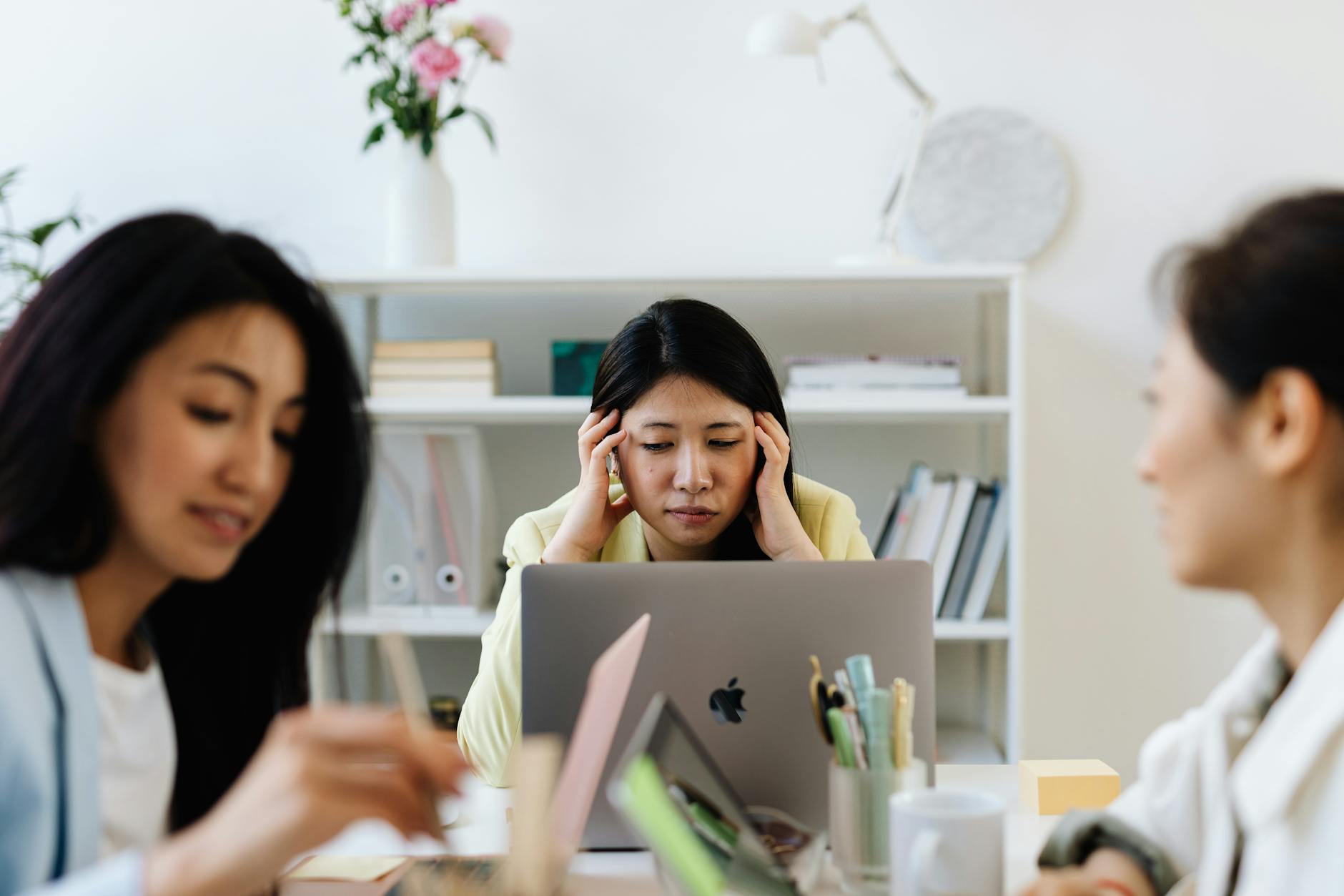 Businesswoman deeply focused on laptop work in a modern office environment.