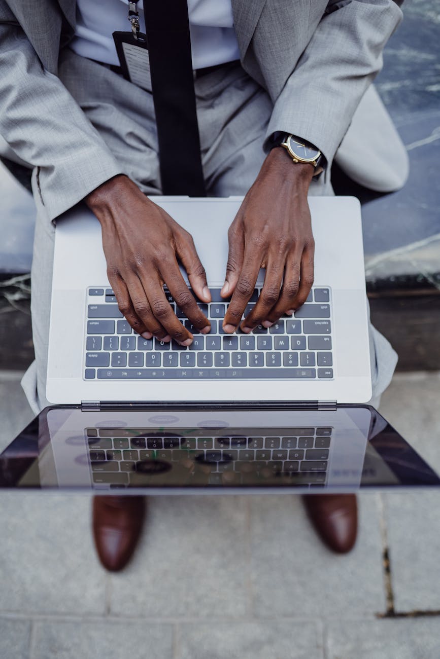 A businessman in a suit typing on a laptop, emphasizing productivity and technology.