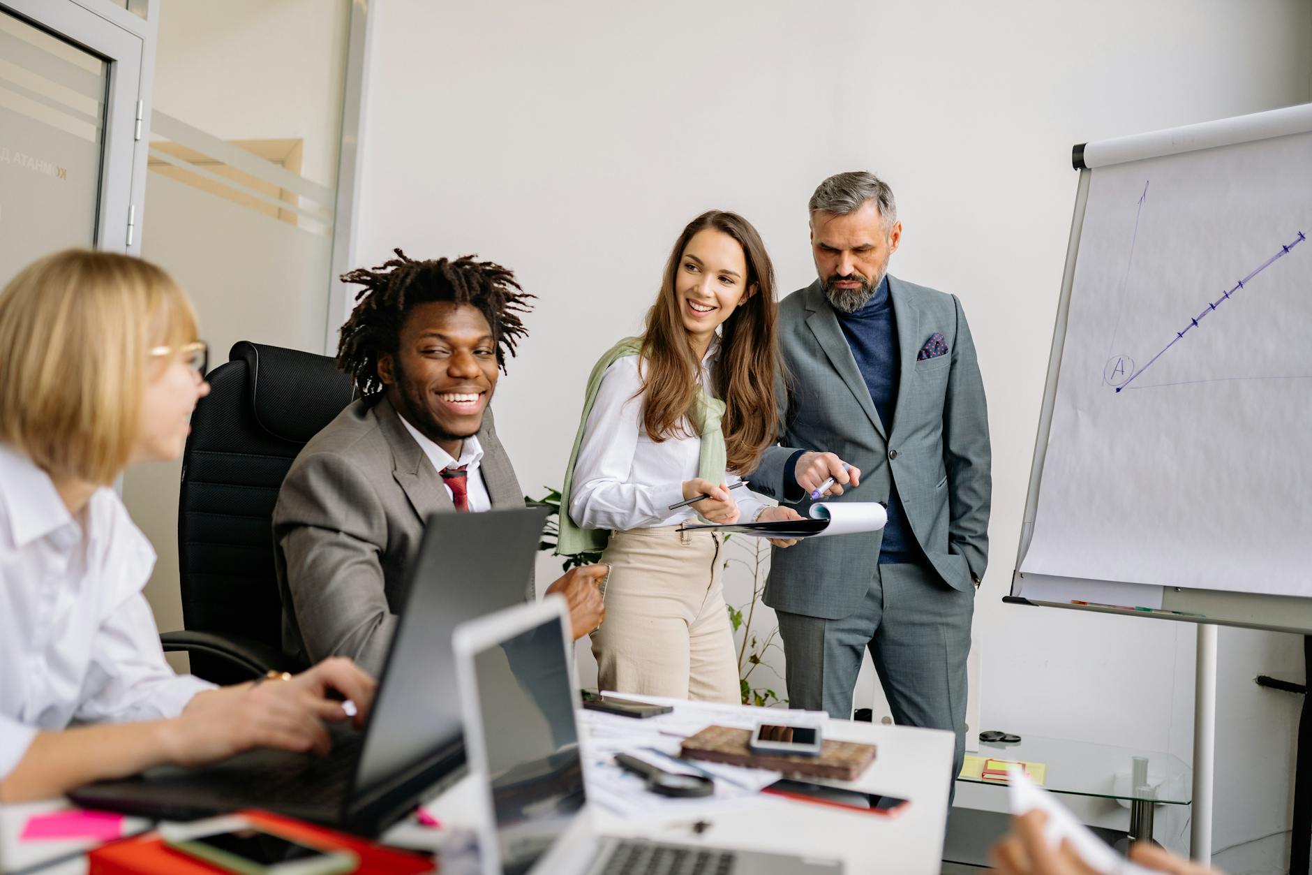 Business team collaborating during a meeting in a modern office space with charts.