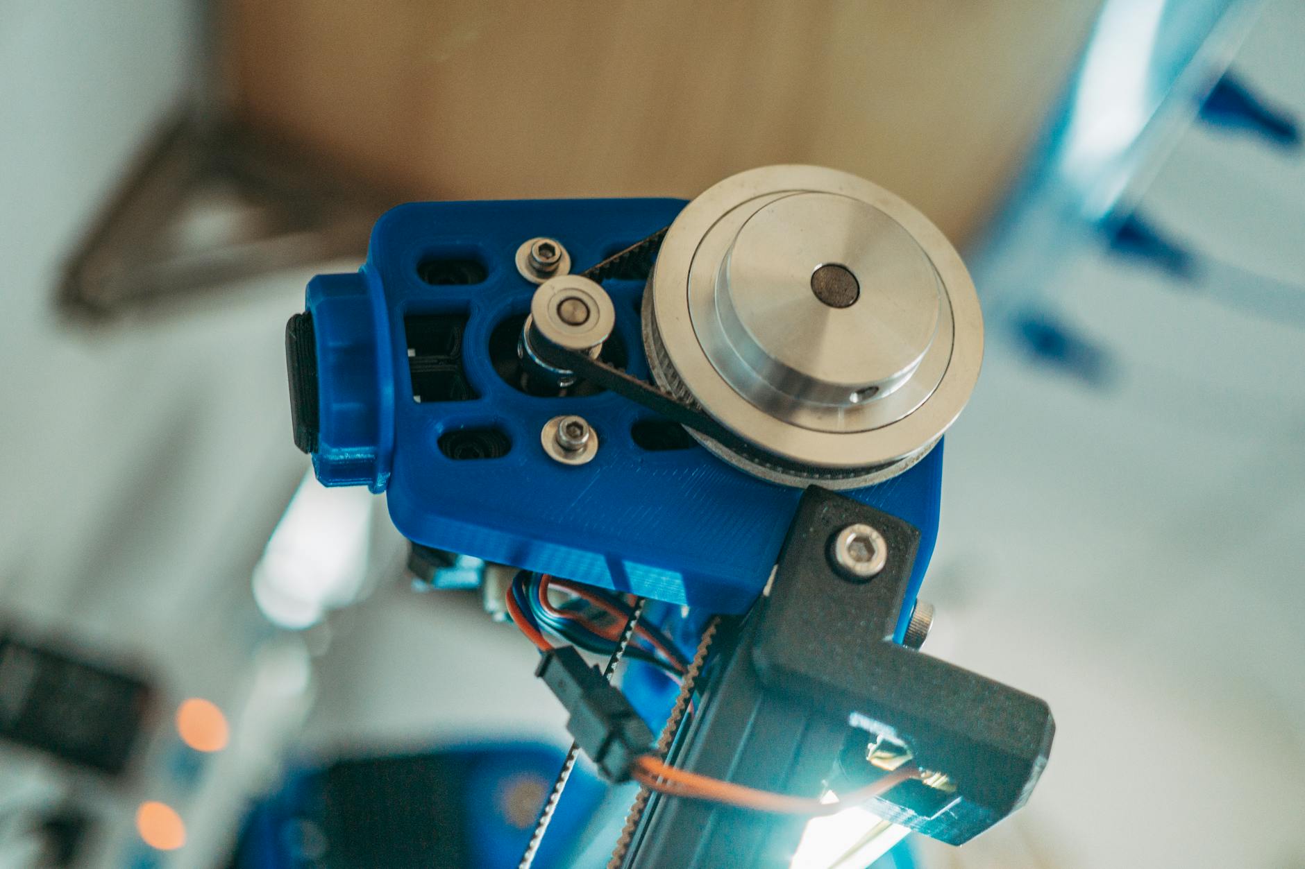Detailed view of a 3D printer's belt pulley mechanism in operation.