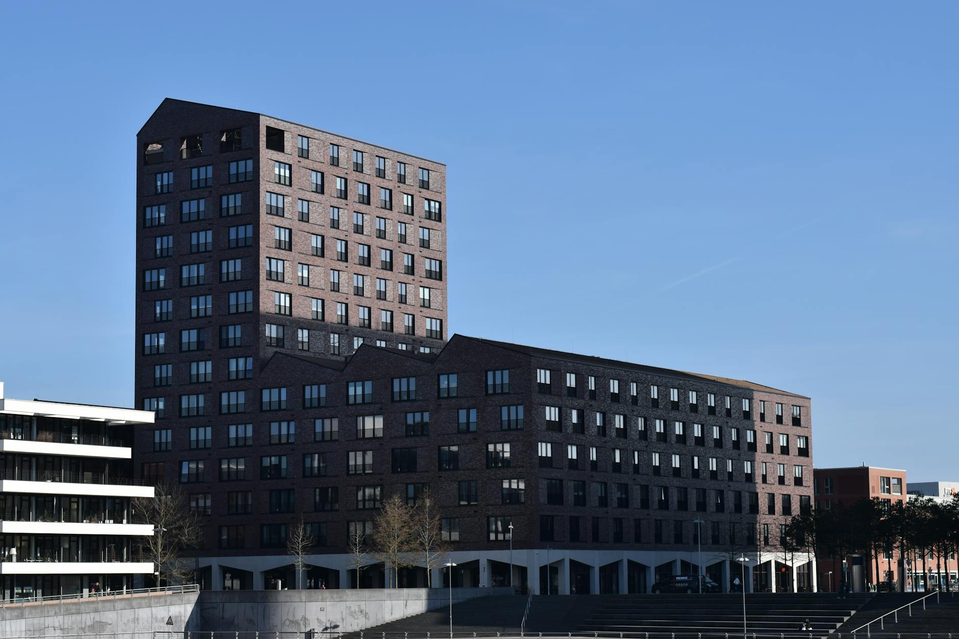 Contemporary brick building in Bremen's Überseestadt against a clear blue sky.